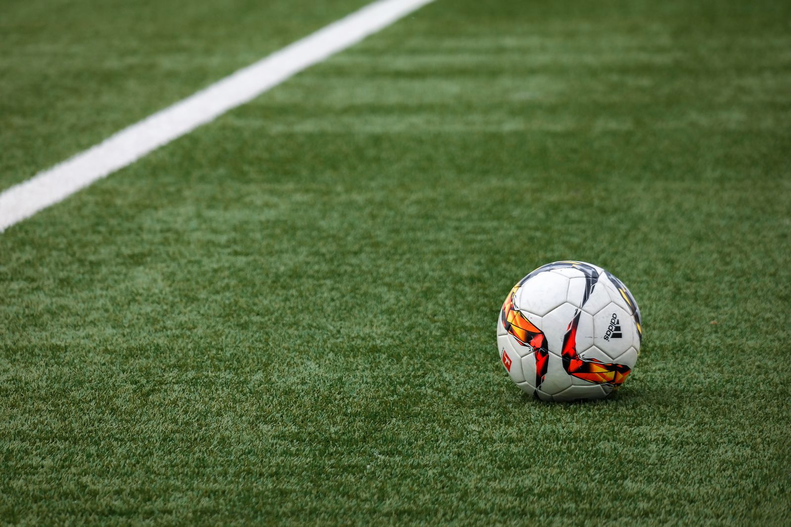 Ballon de football sur un terrain, illustration des paris sportifs